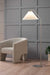 Bradhurst Floor Lamp placed next to a cozy couch, creating a stylish and inviting ambiance.