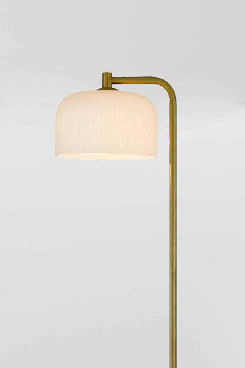 Close up of the florr lamps iron body with an antique gold finish and a glass she with an opal ribbed finish 