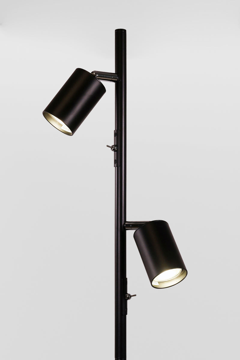 Close up of the black two light floor lamp with black adjustable spot heads and chrome accents.