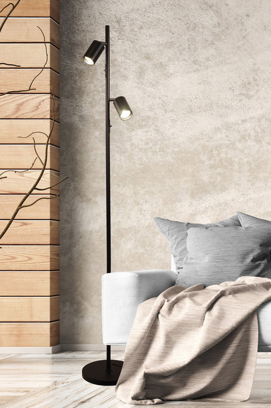 Black two light floor lamp with black adjustable spot heads and chrome accents in a loung room.