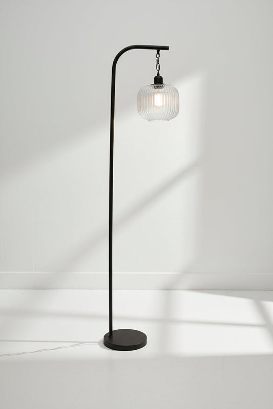 Clear reeded glass shade on a black suspension floor lamp. 