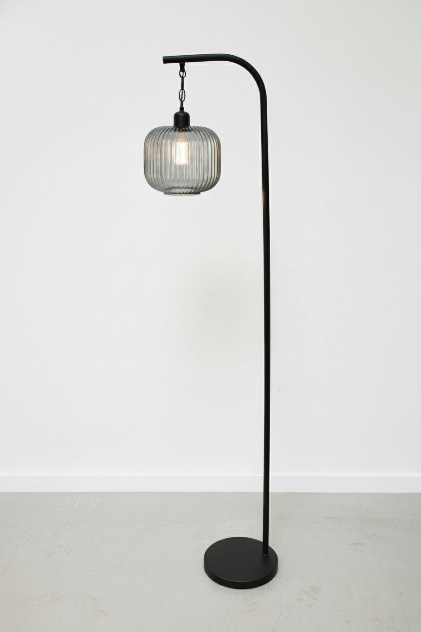 Grey reeded glass shade on a black suspended floor lamp. 
