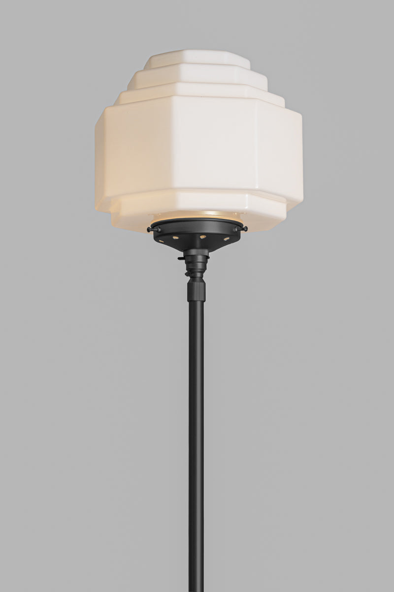 Opal stepped style glass shade on a black gallery and floor lamp stand. 