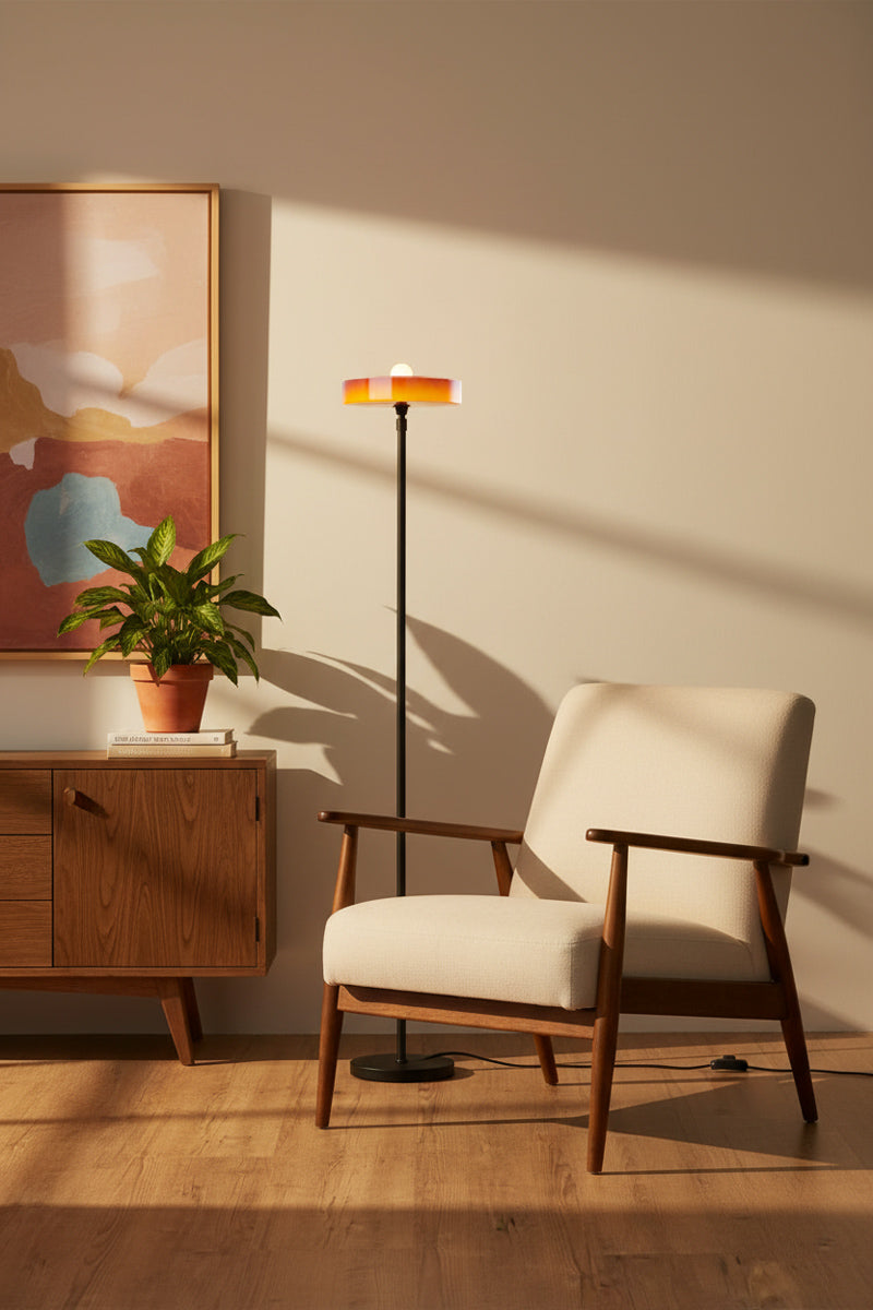 Amber omber glass shade paired with a black stemfloor lamp in a mid century modern inspired reading nook. 