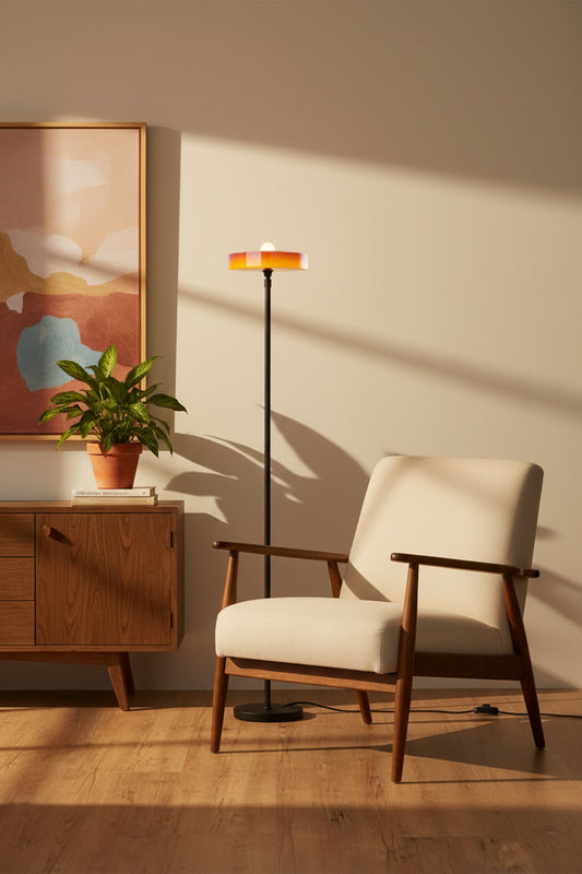 Amber omber glass shade paired with a black stemfloor lamp in a mid century modern inspired reading nook. 
