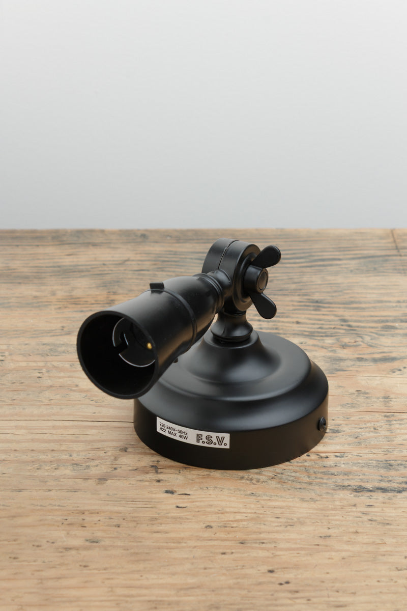 Black batten holder with adjustable lampholder, uninstalled on a timber bench. 