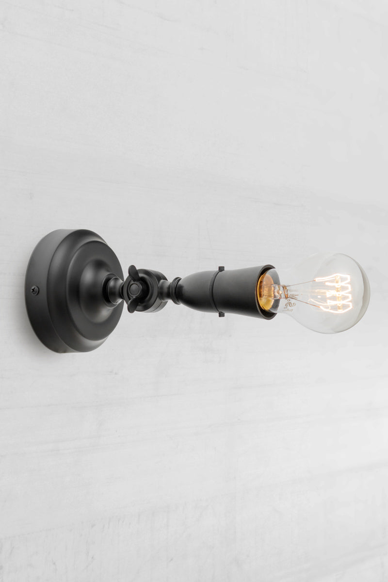 Black batten holder with adjustable lampholder facing vertically. 