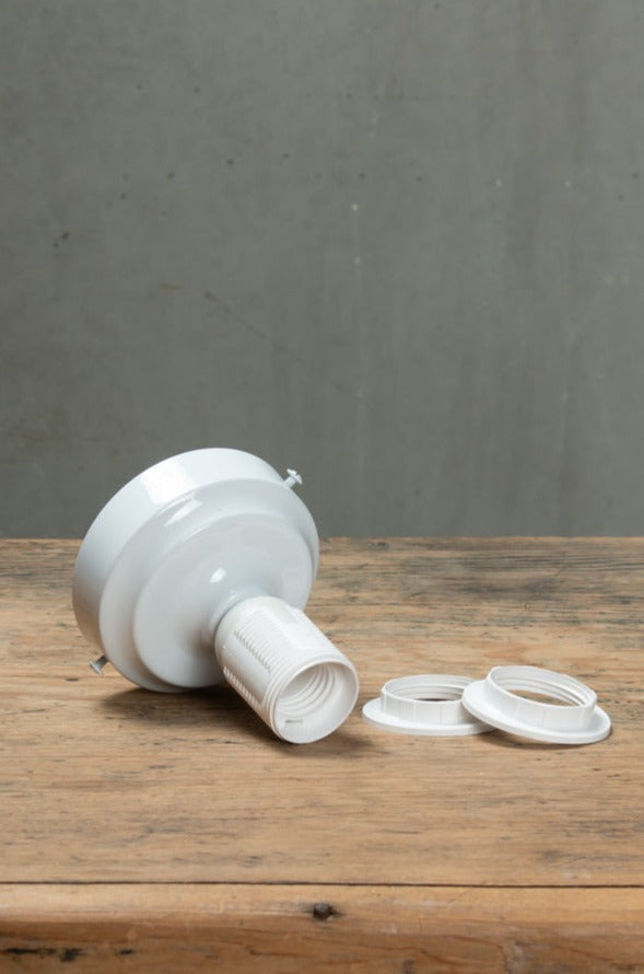 Gloss white batten holder with a curve and O rings on a timber bench. 