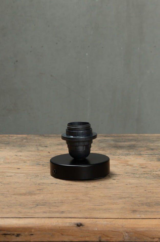 Black batten holder on wooden bench.