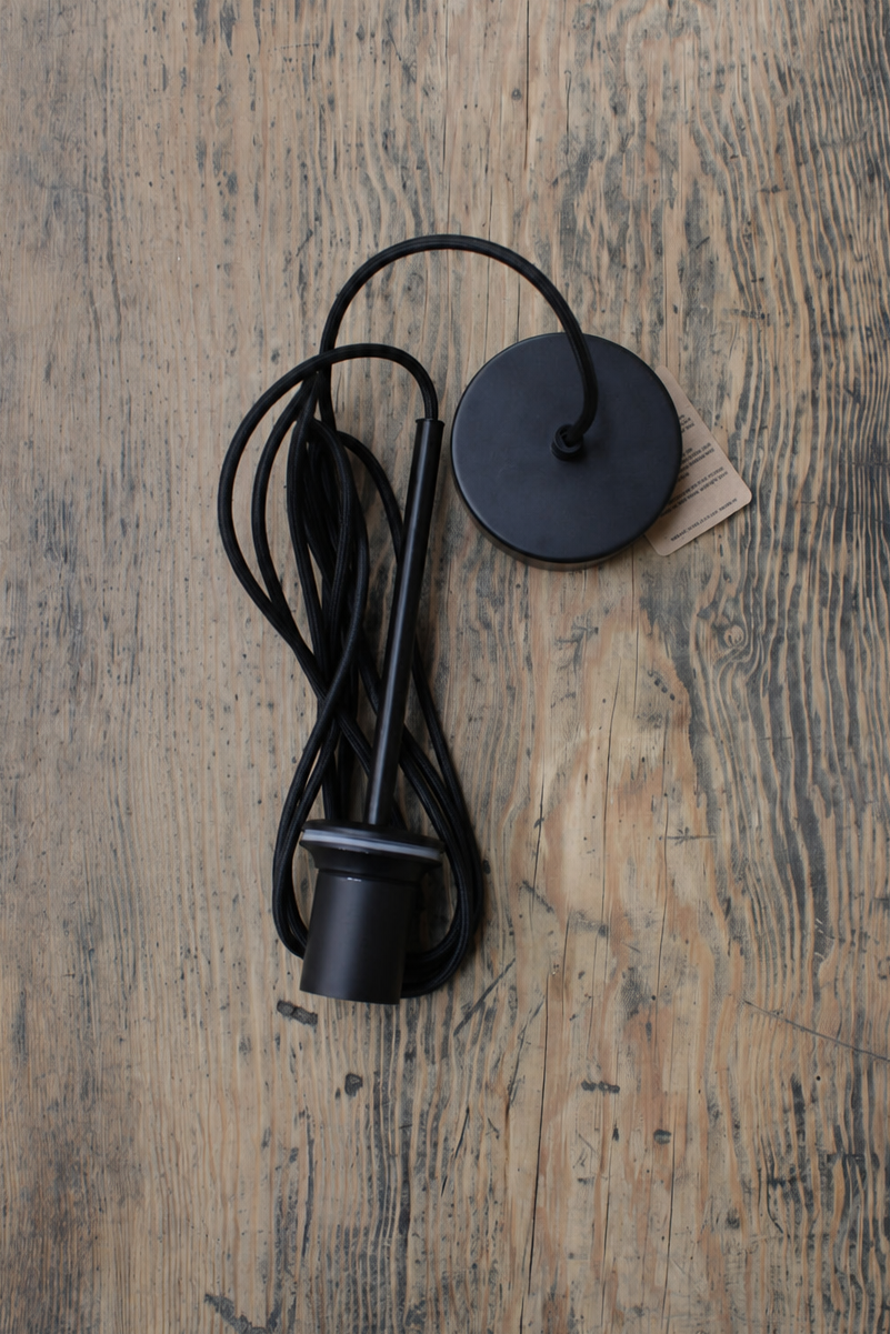 Black Savannah pendant cord placed on a timber bench. 