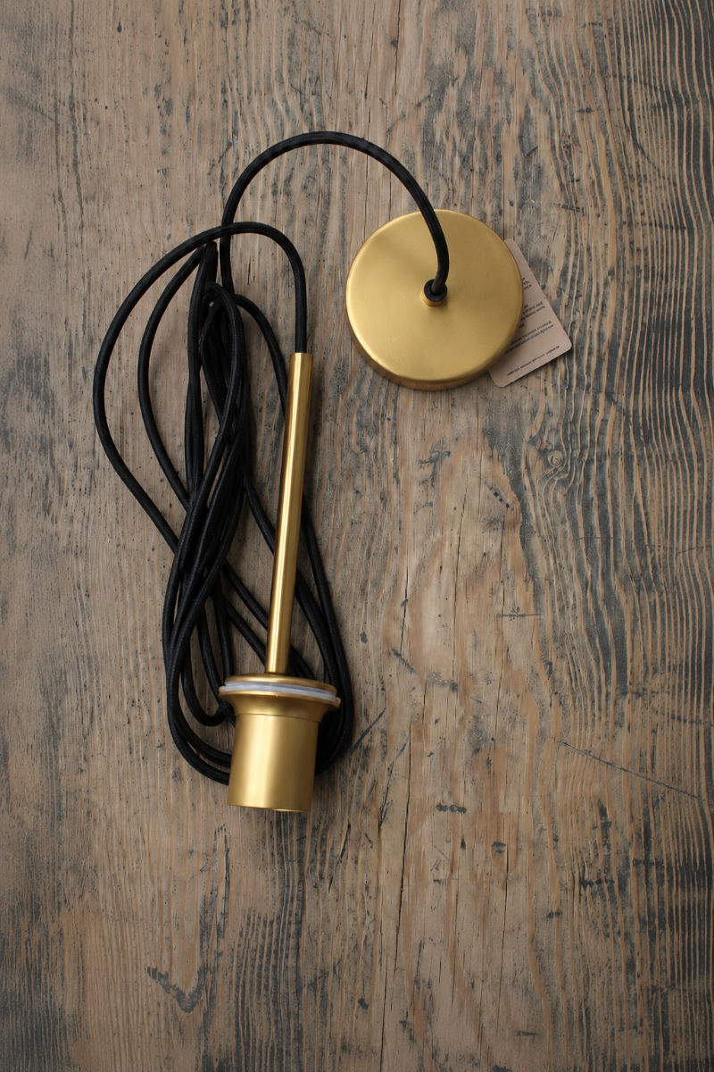 Gold/brass with black cord pendant suspension. 