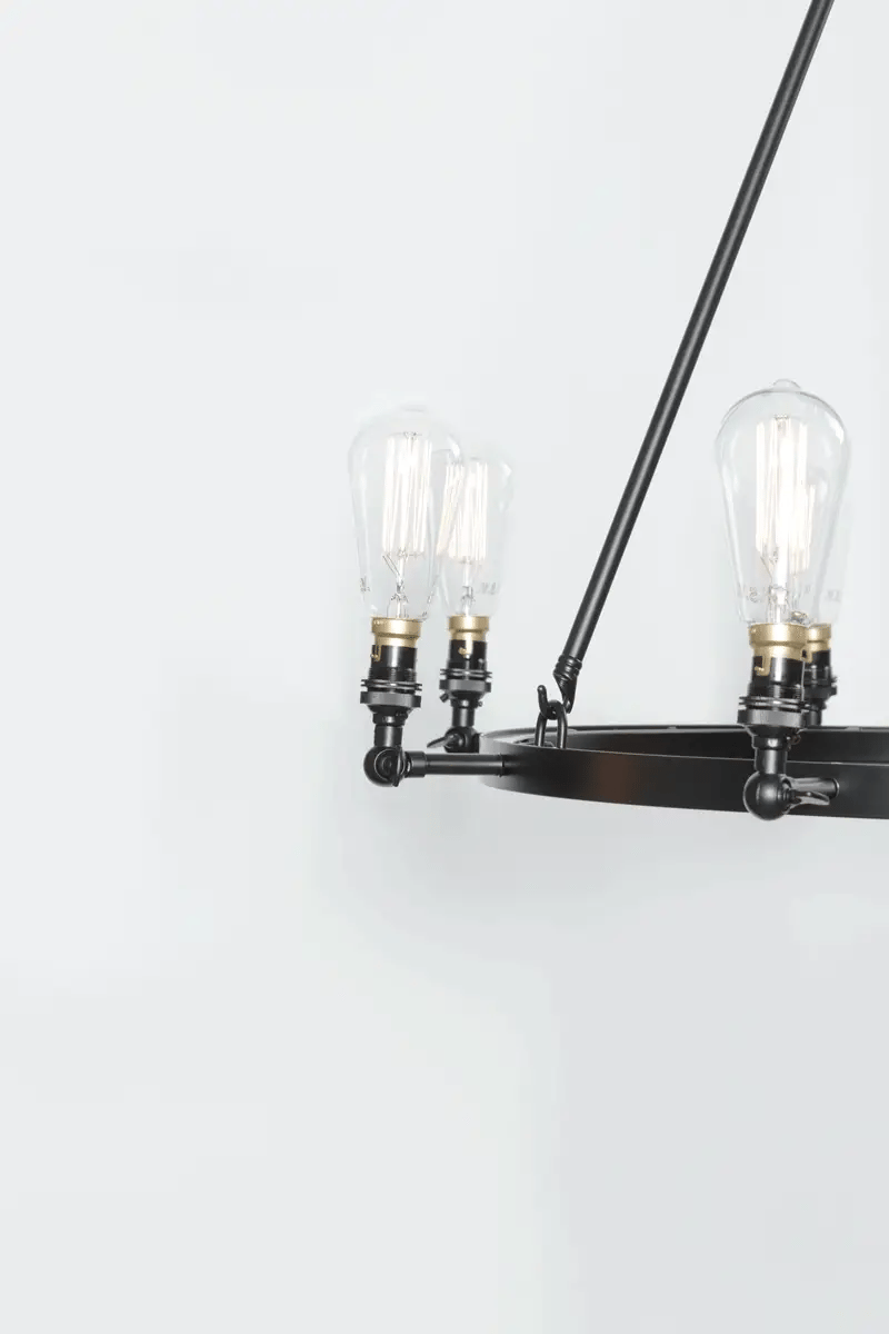large matt black iron ring with eight lampholder arms extending with swivel lampholders for directional lighting.