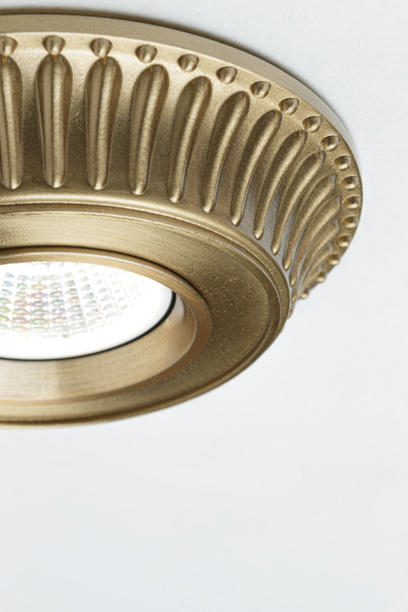 Brass recessed ceiling light with fluted detailing along the outer rim