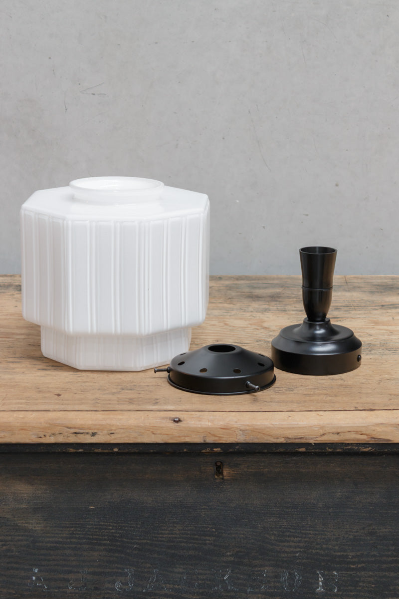 Uninstalled opal glass shade with arte deco inspired detailing, a black batten holder and a black gallery. 