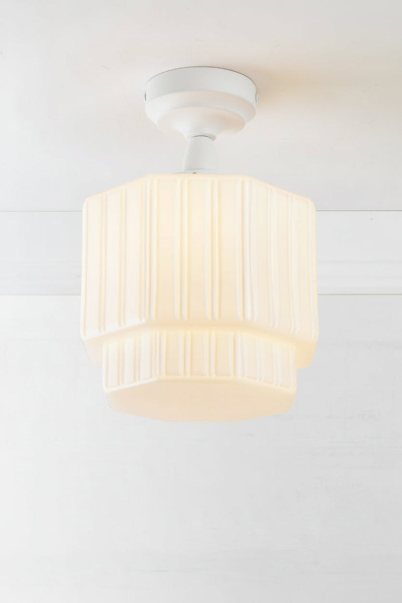 Opal glass shade with step silluette and unique fluted detailing, paired with a white batten holder and gallery. 