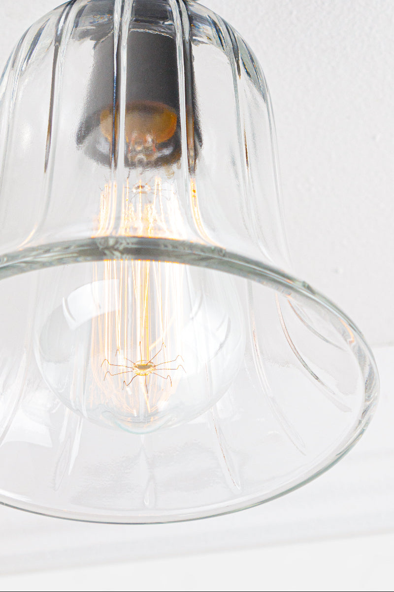bell shaped glass shade is enhanced with a clear finish and has a textured appearance