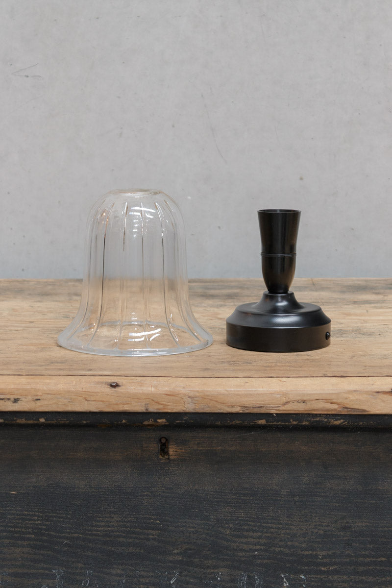 Uninstalled clear glass shade and black batten holder. 