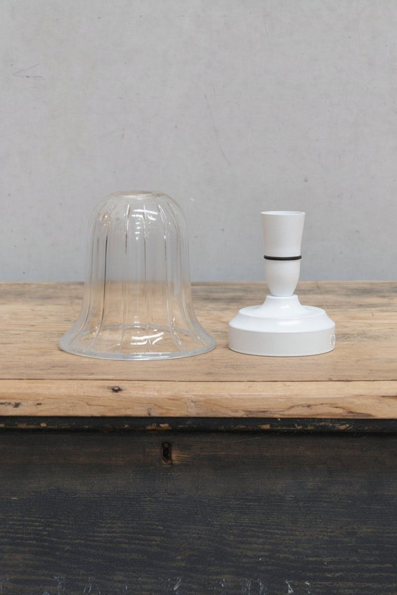 Uninstalled clear glass shade and white batten holder. 