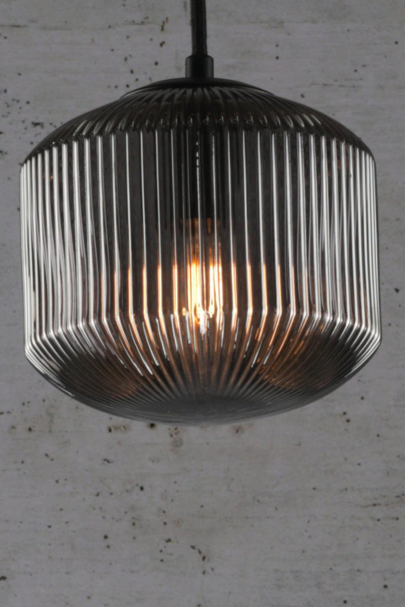 Grey reeded glass shade with black pendant cord. 