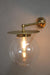gold/brass disc wall light with clear ball shade