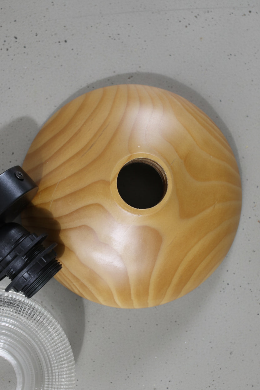 uninstalled circular wood block and wall sconce on a concrete surface. 