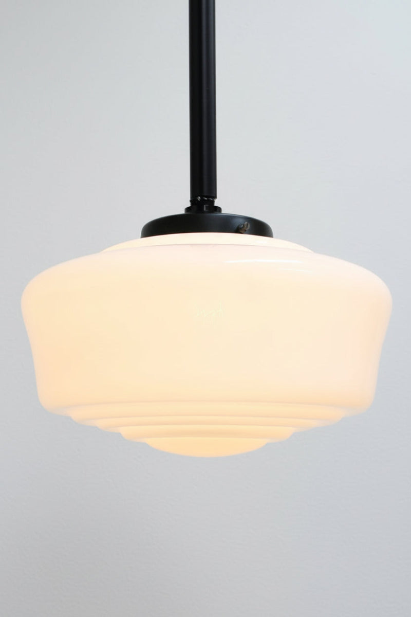 Opal glass schoolhouse style shade on a black pole pendant. 