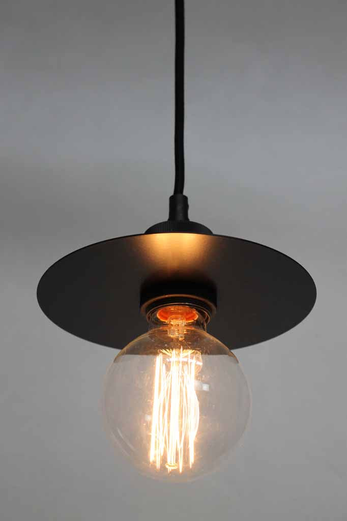Small black metal disc feature on pendant light. 