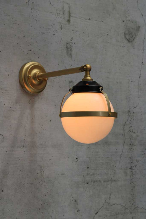 Huxley wall light with long gold arm and small opal shade