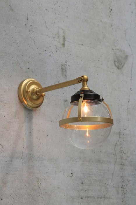 Huxley wall light with small clear shade and long gold steel arm