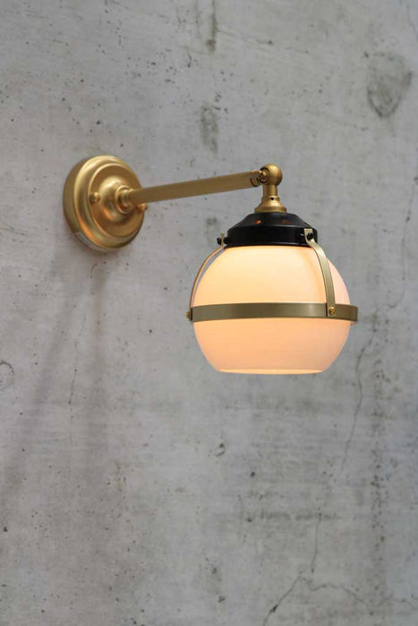 Huxley wall light with long gold arm and small open opal shade 