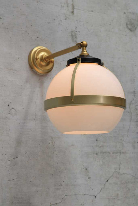 Huxley wall light with long gold arm and medium open opal shade