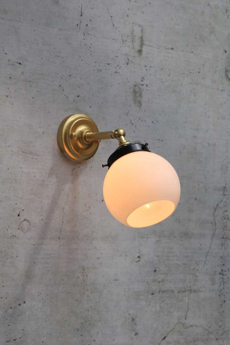 small adjustable wall light in gold/ brass finish with small opal wall light