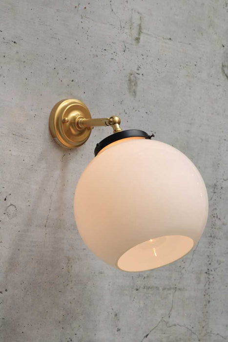 small adjustable wall light in gold/ brass finish with medium opal wall light