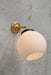 small adjustable wall light in gold/ brass finish with medium opal wall light