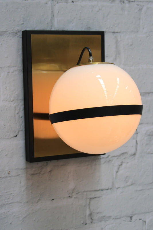  The wall mount a bold combination of black steel with brushed brass. 