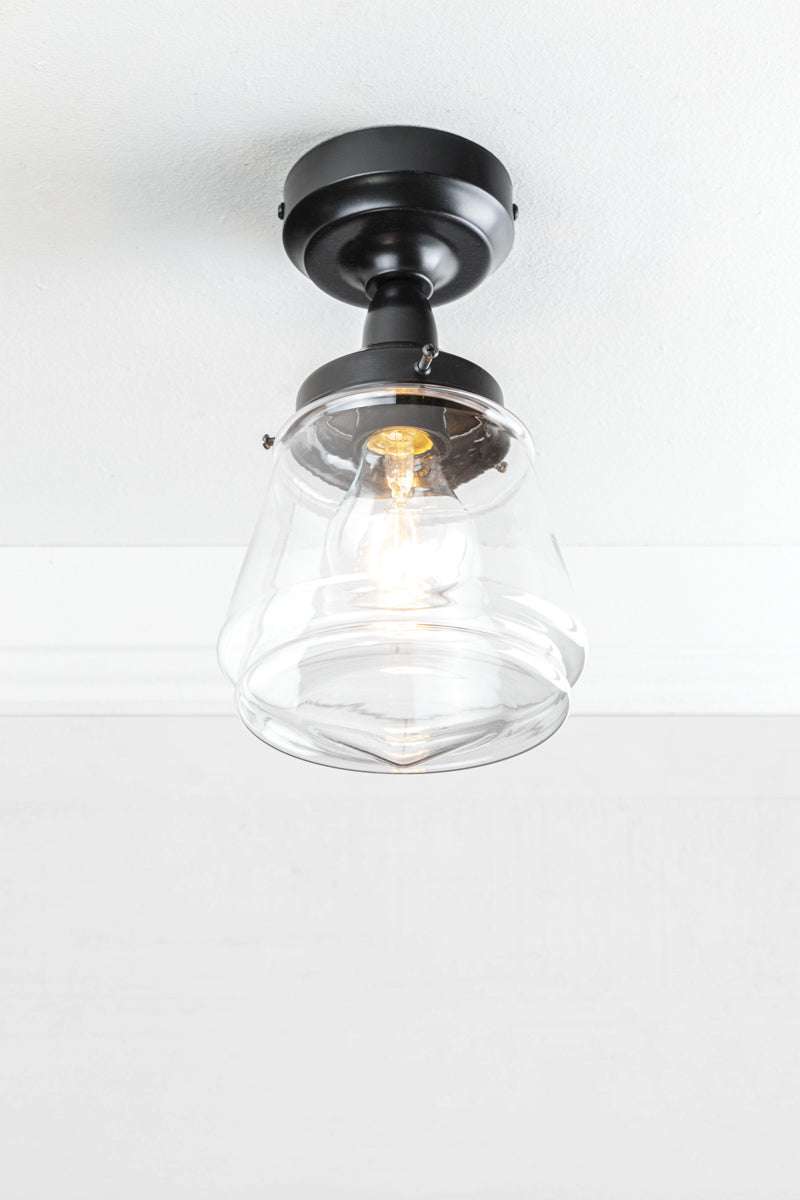 Clear Deco inspired glass shade with a clear bulb and black batten holder. 