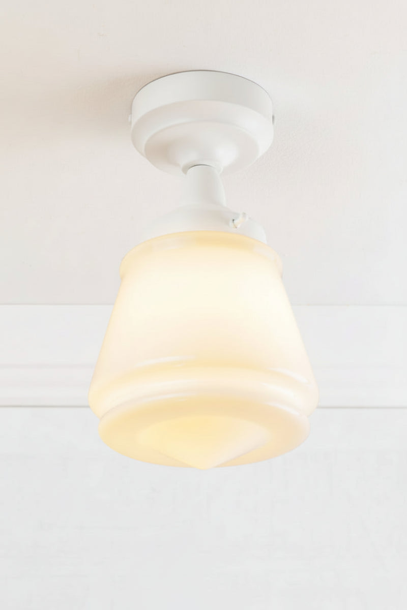 White batten holder paired with a n opal glass shade on a white ceiling. 