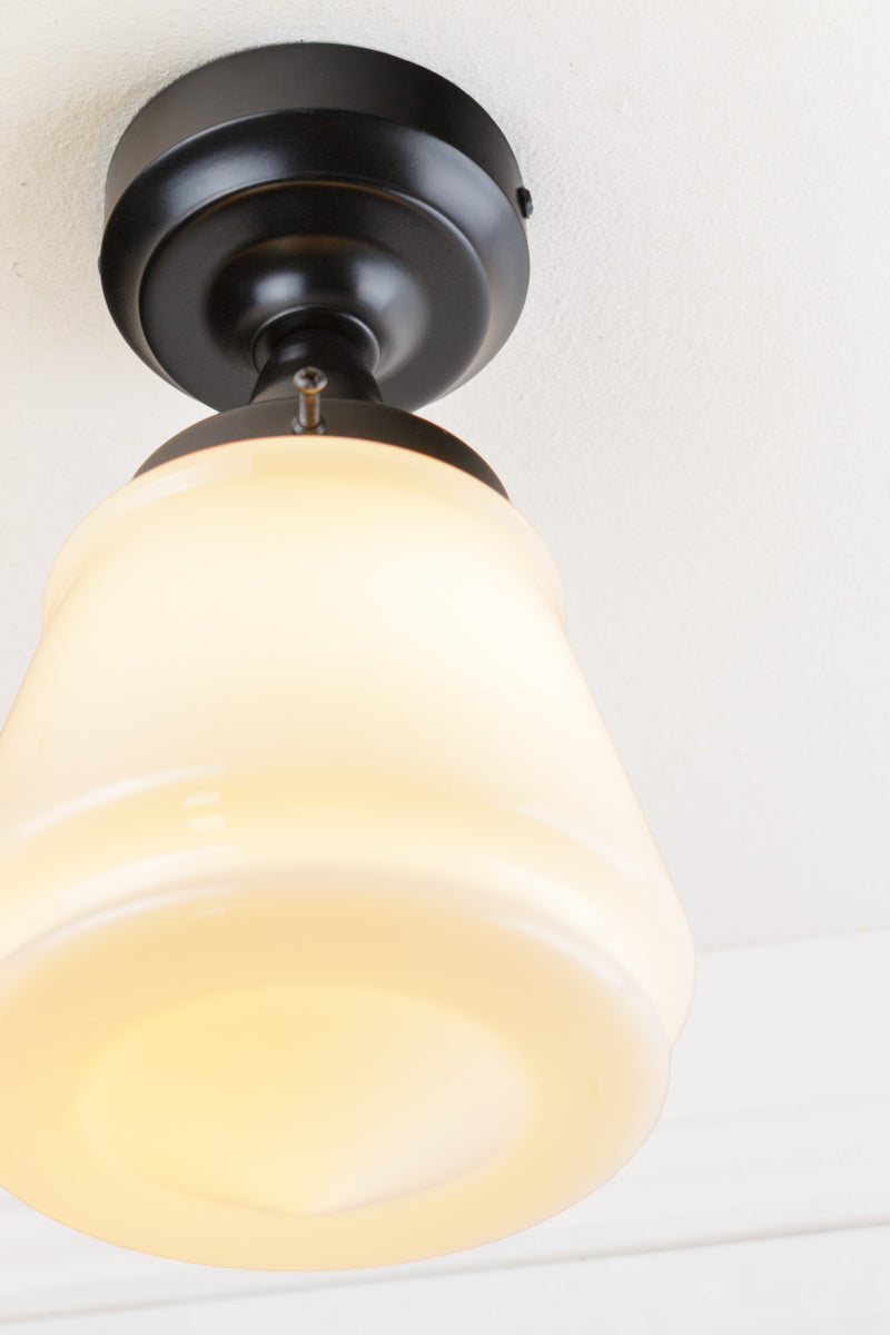 Close up of the opal Deco inspired glass shade paired with a black batten holder. 
