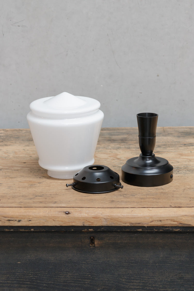 Uninstalled ceiling light KIT with an opal deco shade, black gallery and black batten holder on a timber bench. 