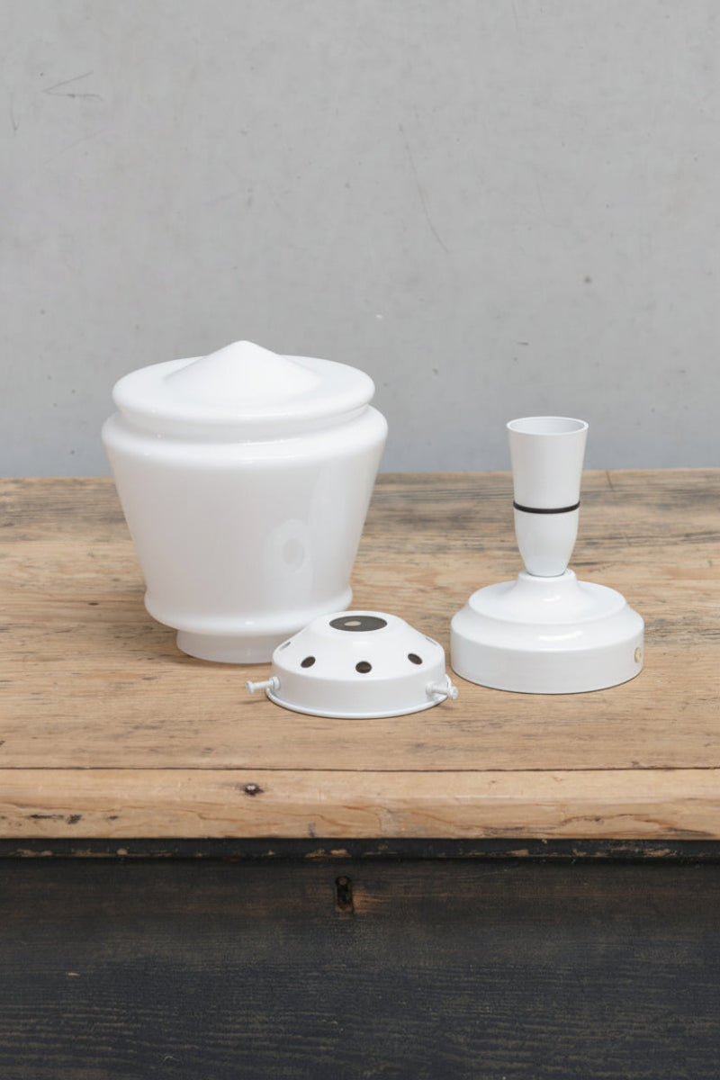 Uninstalled ceiling light KIT with an opal deco shade, white gallery and white batten holder on a timber bench. 