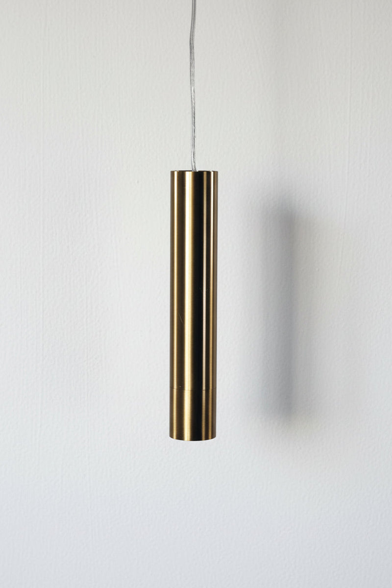 Satin Brass cylindrical pendant light with clear cord. 