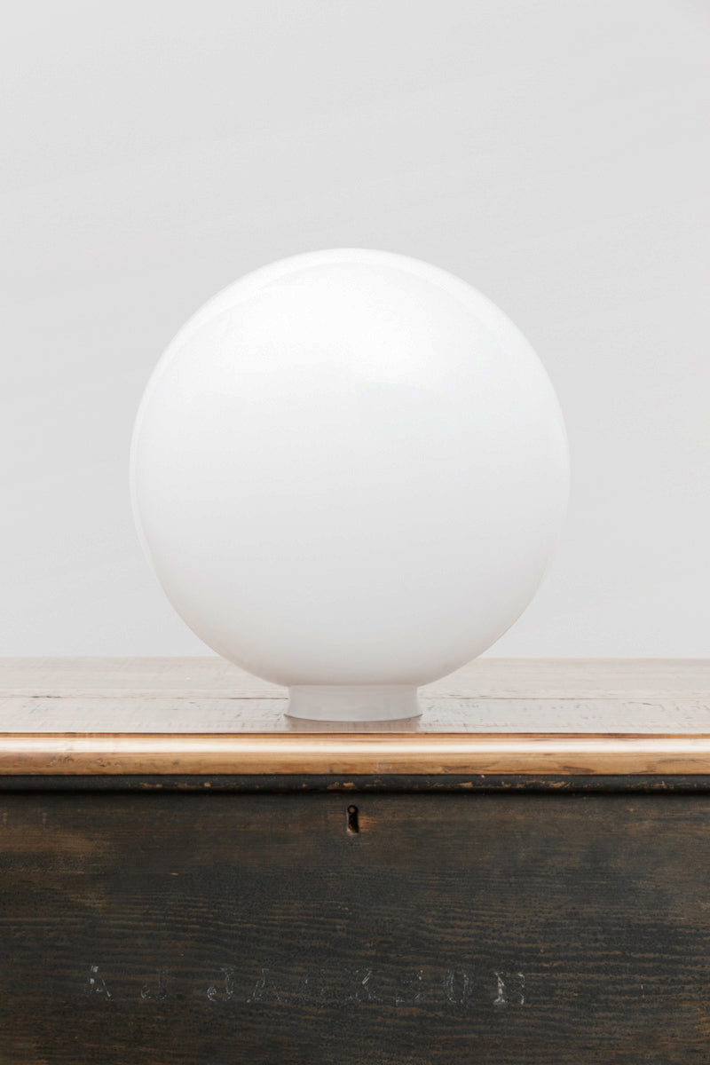 Large opal glass ball shade on a timber bench. 