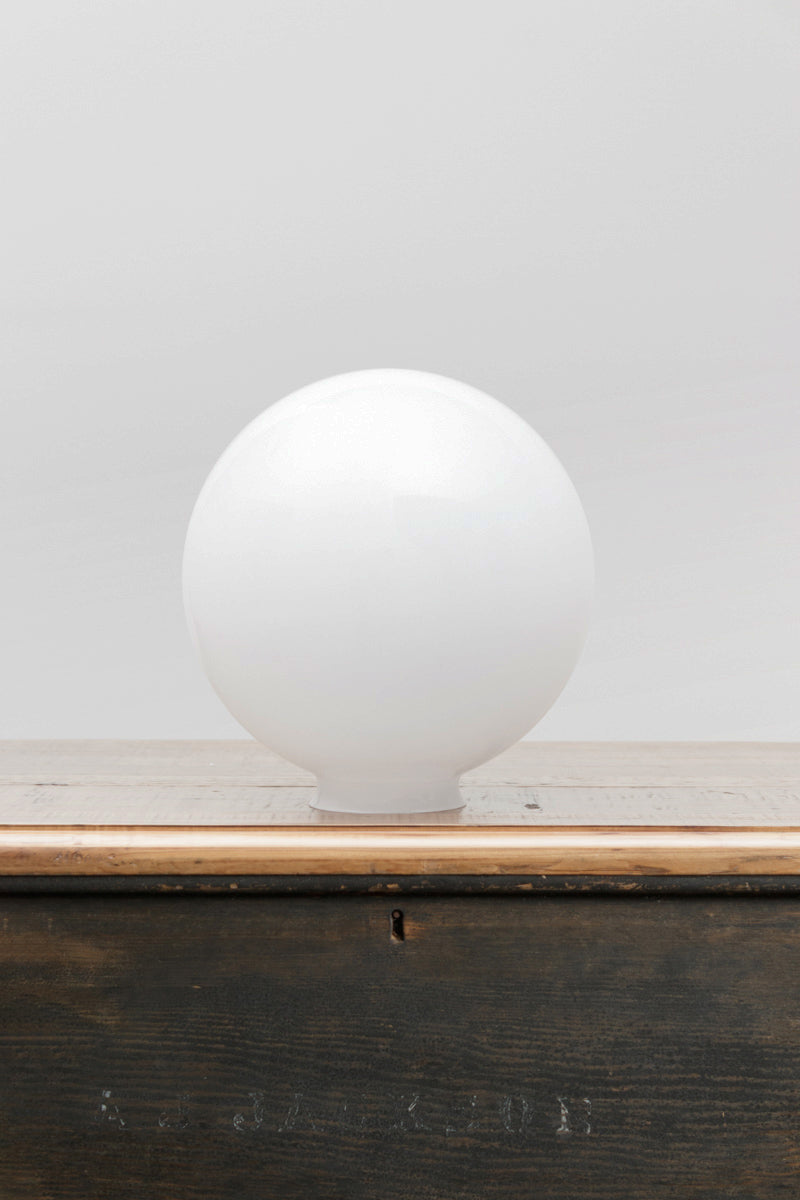 Medium opal glass ball shade on a timber bench. 