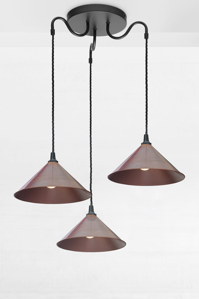 Large copper cone shades on a black three arm gooseneck multi drop fixture.