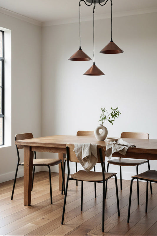 Aged copper 3 light pendant over a dining space.