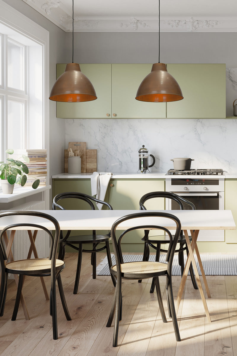Two brass loft pendant lights with black cords in a clean australian style kitchen. 