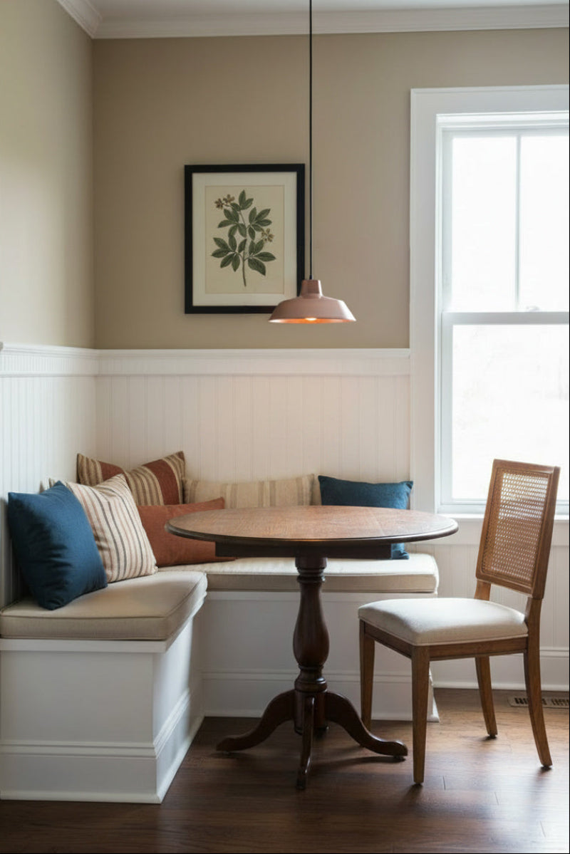 A cozy kitchen corner featuring a built-in bench, a round table and a copper-facotry pendant light in Edwardian residence