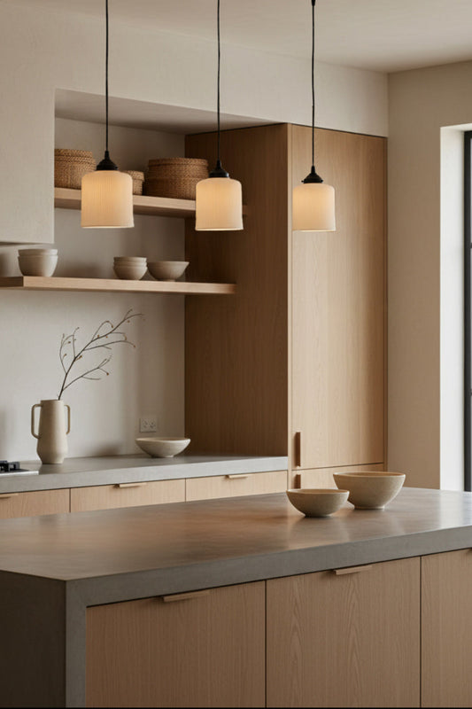 Modern kitchen with 3 ceramic pendant lights over wooden cabinets in a neutral color palette.