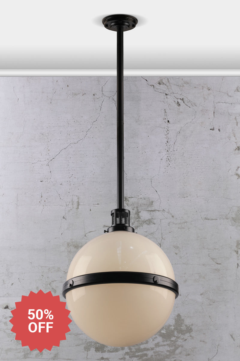 Black steel pole pendant light with an opal glass ball shade and industrial detailing. 