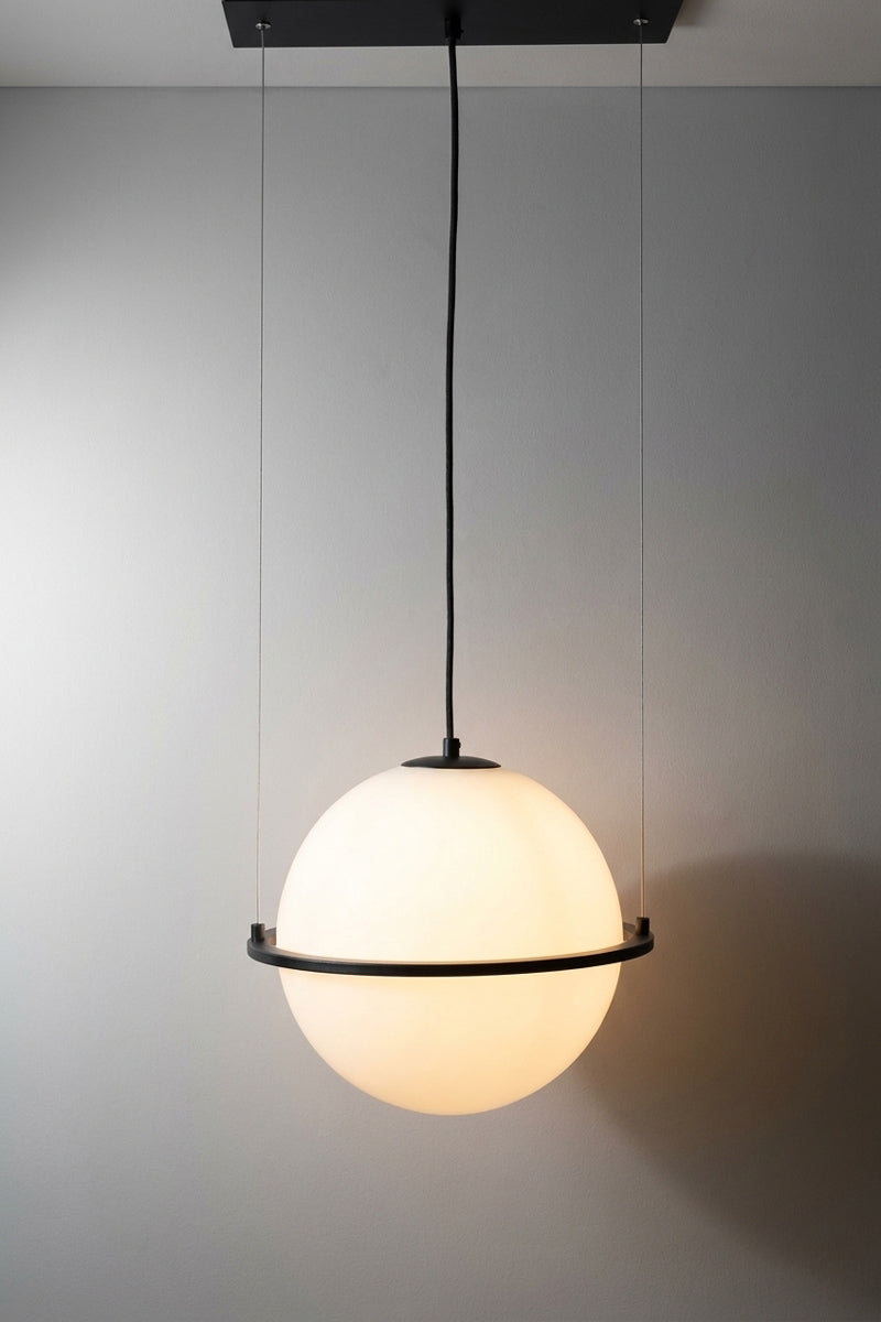 White sphere pendant light with a black metal ring, hanging from a black ceiling canopy